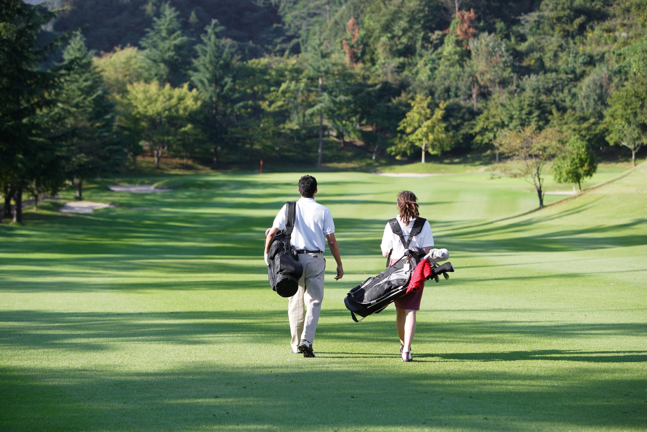 Golfers walking the course with their clubs